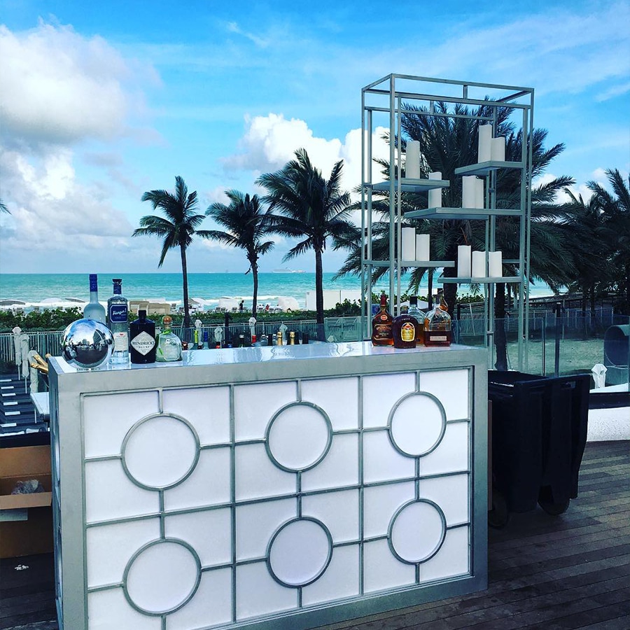 Outdoor conceptual bar setup with ocean view and palms