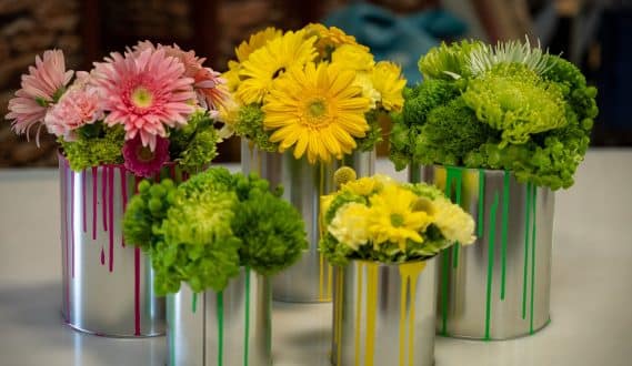 Colorful floral centerpieces in painted silver tin vases