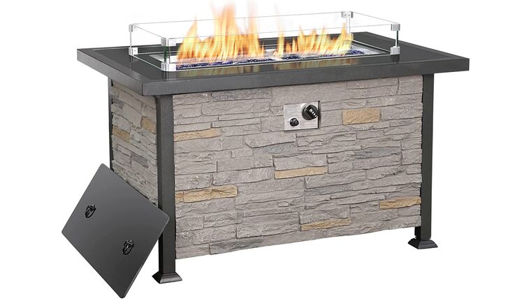 A rectangular stone fire pit table with a modern design, featuring glass panels on top and a metal control knob.