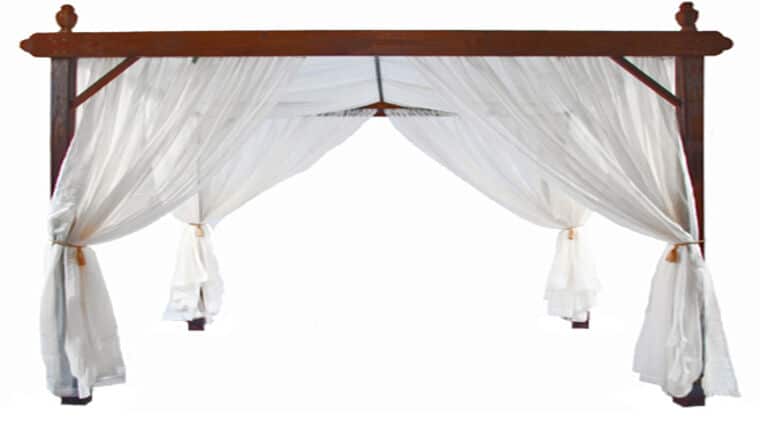 Large Mahogany Cabana Wooden pergola with sheer white curtains tied back at the corners, creating an elegant and airy appearance.