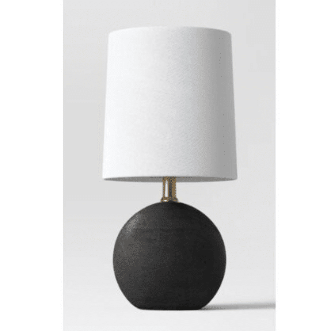 Round Textured Black Table Lamp with a white cylindrical shade and a spherical black base, featuring a gold neck. The design is minimalist and elegant.