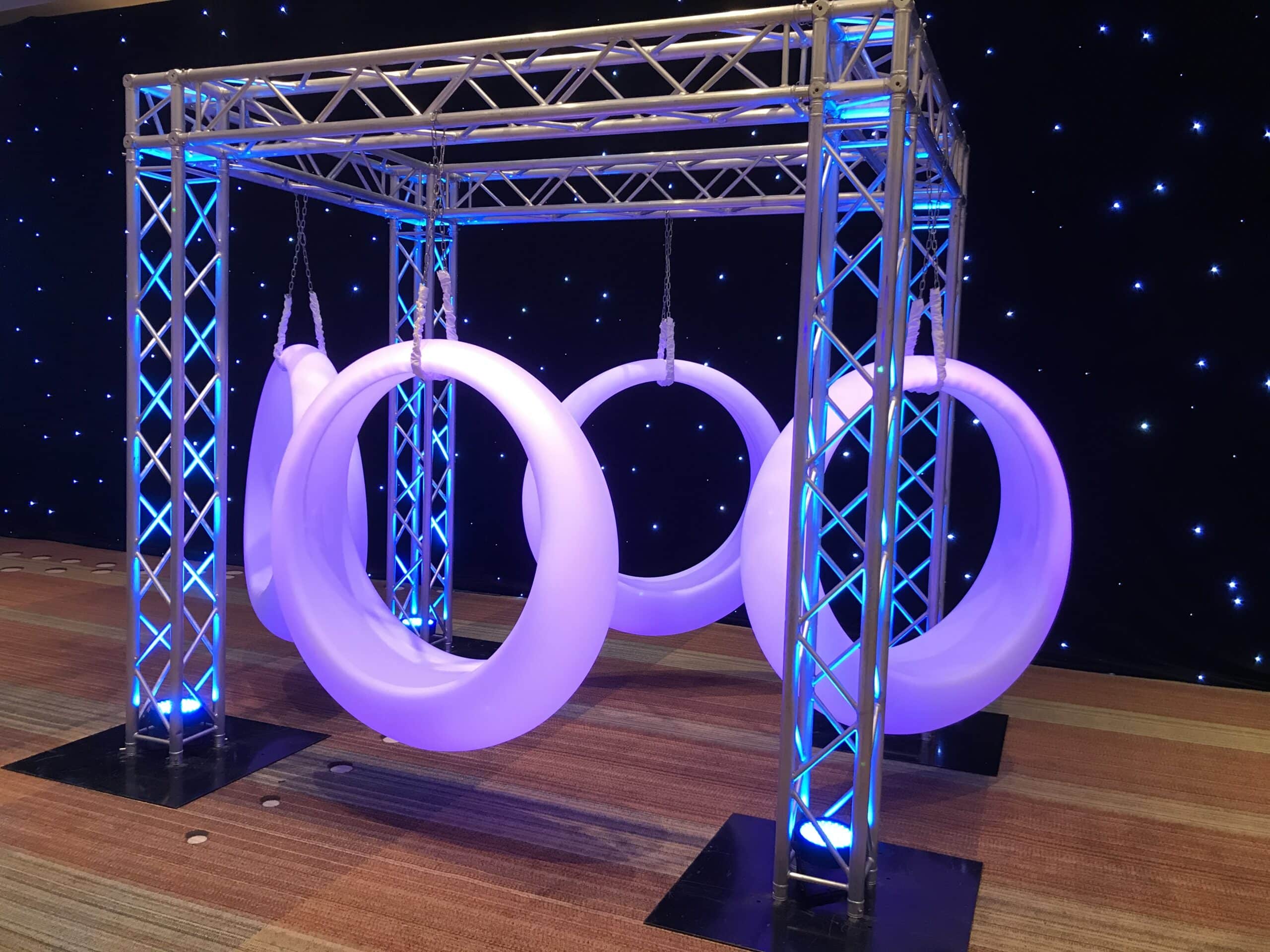 Colorful indoor event with draped ceiling and uplighting